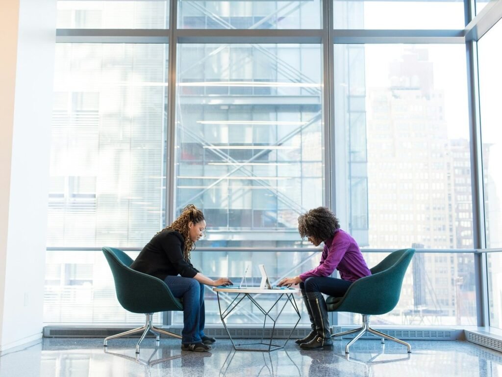 Two colleagues working at a table beside a window